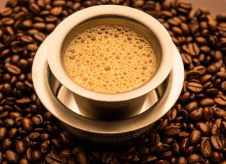 South Indian Filter coffee served in a traditional tumbler or cup over roasted raw beans Photo Subodh Sathe via iStock