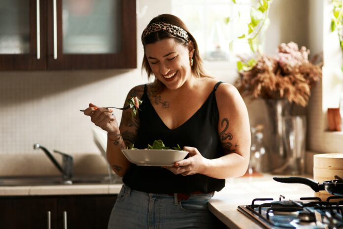 Woman,,Diet,And,Person,Eating,Salad,In,Her,Home,Kitchen food